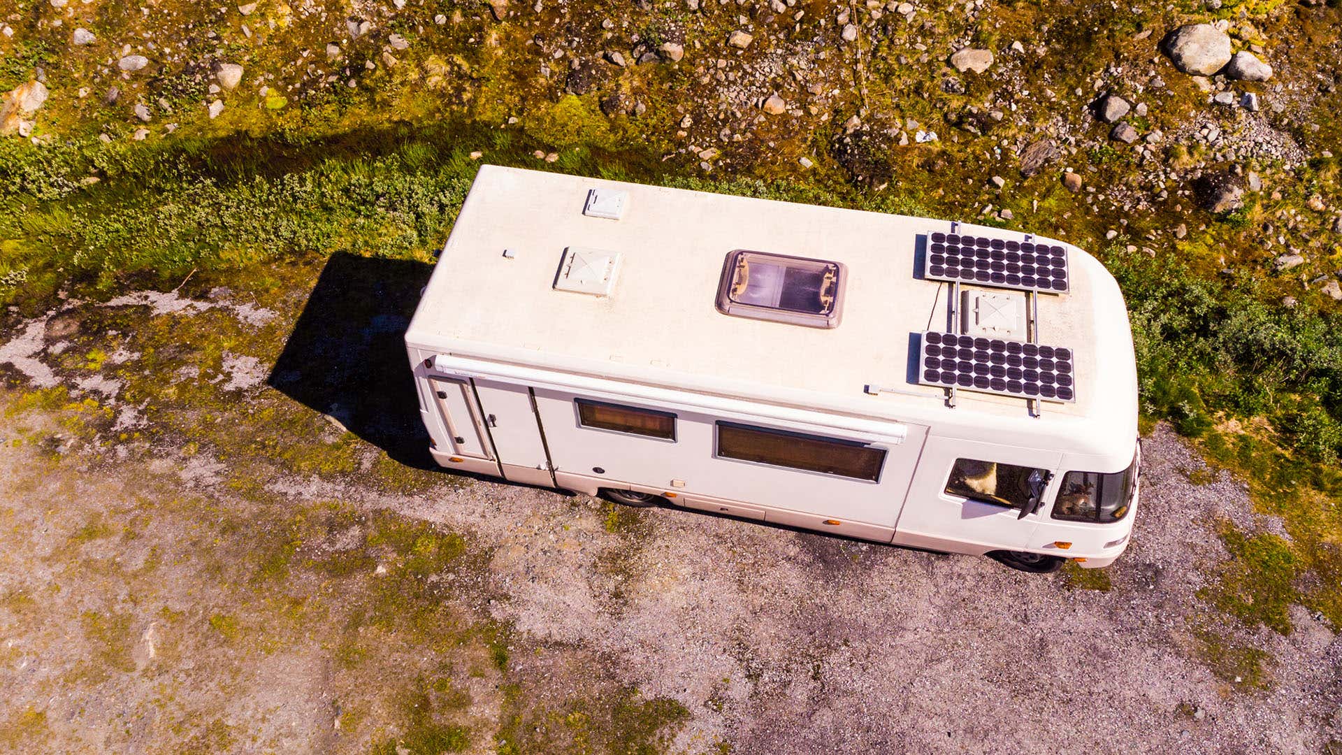 一辆装有太阳能电池板的房车停在大自然中。