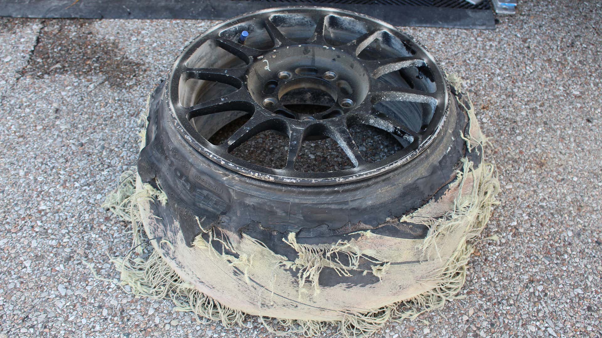 在赛车轮上的撕裂的轮胎。