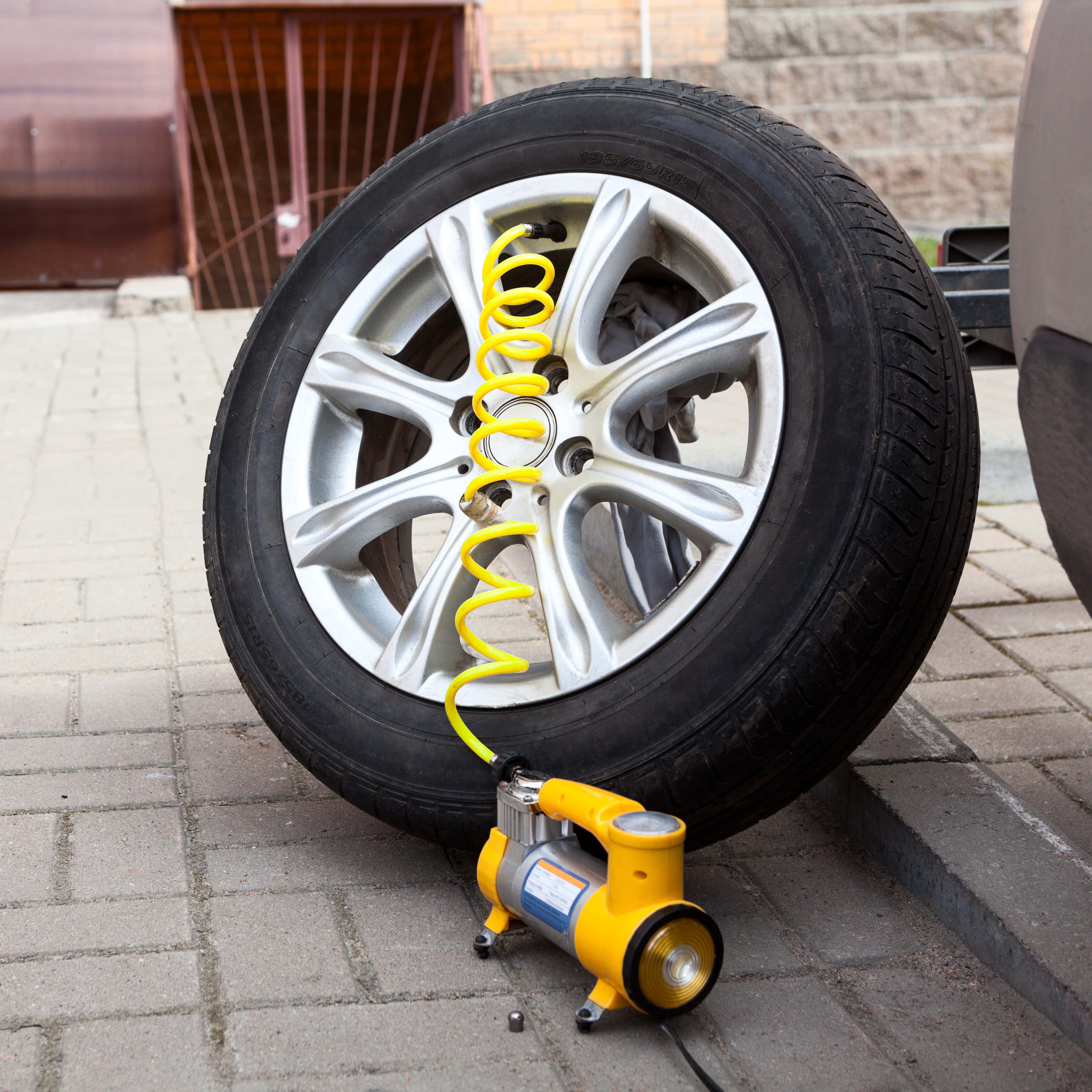 一个黄色的轮胎打气筒正在给车的一个轮胎打气。