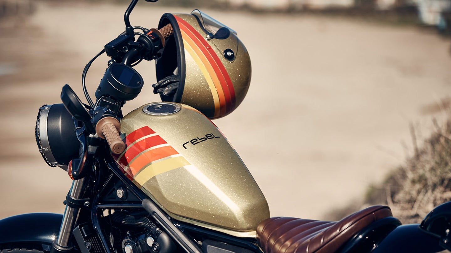 金色摩托车气罐与复古条纹和匹配的金头盔。